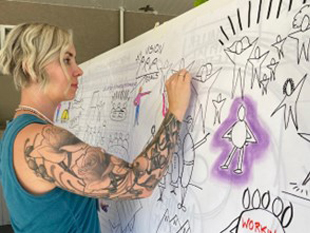 In-person Fundamentals of Visual Coaching class: Student drawing intently at the easel.